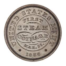 Silver medal with raised lettering.