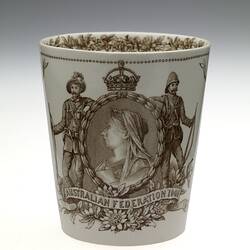 Cream earthenware beaker with sepia floral patterning. Two soldiers frame cameo of Queen Victoria.