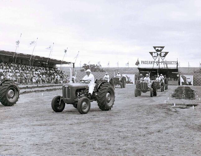 Tractors on display in front of grandstand.