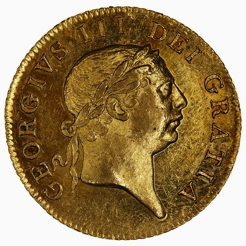 Gold coin with male profile facing right, text around.