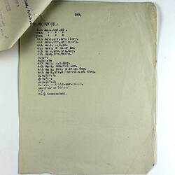 Off-white paper with printed text, stapled to other pages in top-left corner.