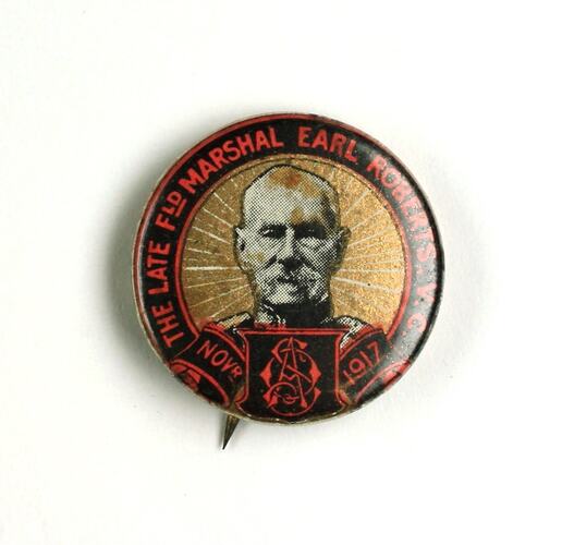 Badge with black and red banner, male head.