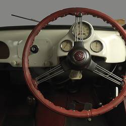 Detail of brown steering wheel and instrument panel.