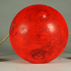 Red cylindrical container with two electrical cords at one end.