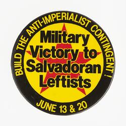 Yellow round button badge with black border and text. Red star in centre. Yellow text in black border.