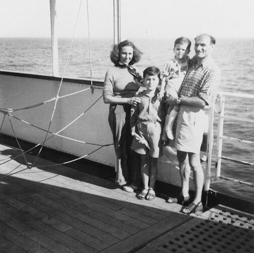 Family posing on ship deck.
