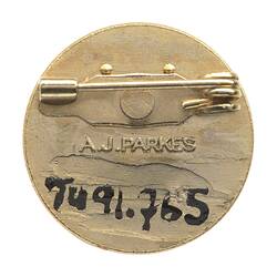 Back of round metal pin badge.