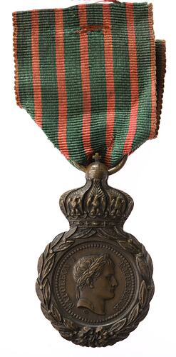 Round medal with male profile facing right. Red and green striped ribbon.