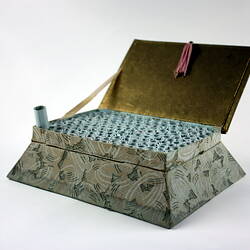 Open box with scrolls inside.