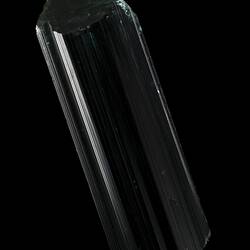 Dark green prsimatic crystal on black background.