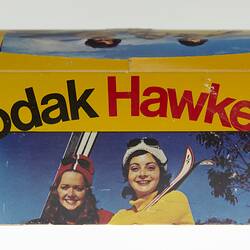 Yellow cardboard box with image of two women.