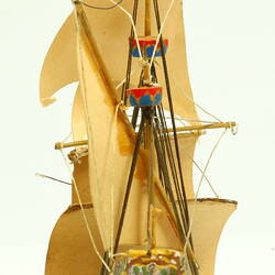 Rear view of three masted ship with wooden hull.