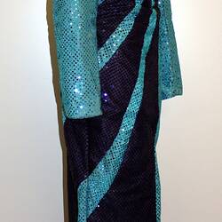 Side view of light blue full length sequin dress with dark blue swirls from shoulder to hip.