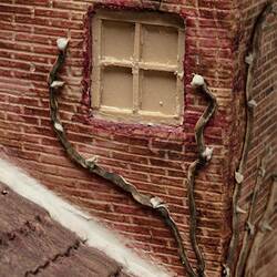 Model of red brick cottage and garden made from icing. Window detail.