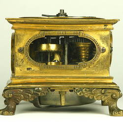 Decorative table clock, square gilded brass case on four feet.