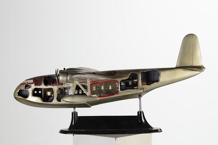 Green-silver model aeroplane on stand. Cutaways on side show interior.