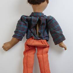 Back of doll with red pants, blue top and short brown hair.