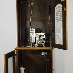 Wooden clock with both top and lower cabinet doors open. Mechanism visible.