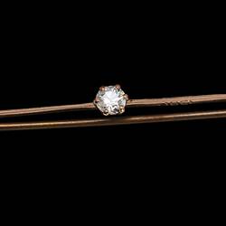 Rose gold bar brooch with three paste stones. Purple at left end, white in centre and light green at right end.