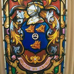 Detail of stained glass window showing a coat of arms.
