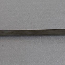 Metal pendulum lying flat.