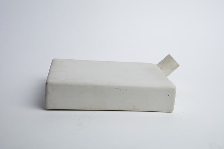 Narrow, white, rectangular ceramic container with cylindrical spout/opening at top right.