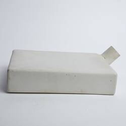 Narrow, white, rectangular ceramic container with cylindrical spout/opening at top right.