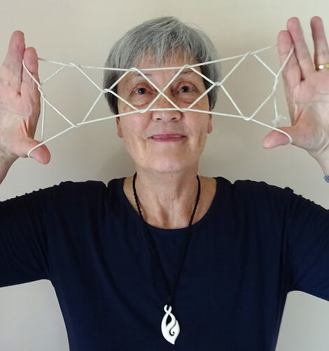 Woman holding string shape.