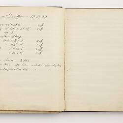 Open book with off white pages. Handwritten text on left page.