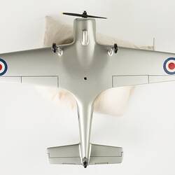 Underside of model aeroplane, silver with black propeller and wheels. Red, white, blue roundels on wings.