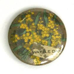 Badge with pale blue background and green and yellow golden wattle and text.