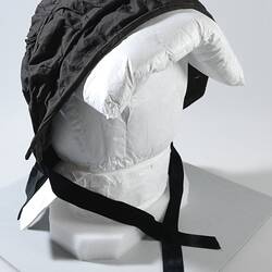 Black bonnet with ties around the chin.