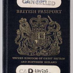 Dark blue passport front cover with gold printing. Logo in centre. Two cut out strips at top and bottom.
