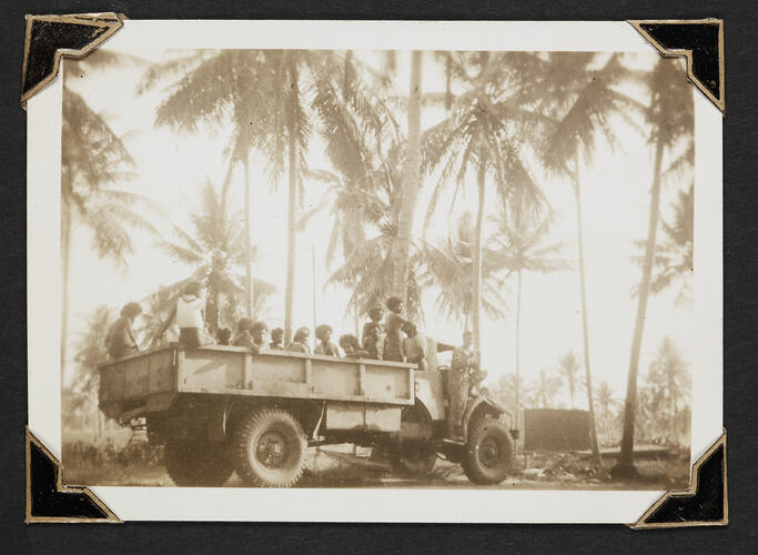 Group of people riding on the trailer of truck.