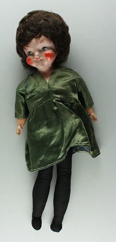 Female doll, porcelain head with short brown hair. Soft body. Wearing olive green satin dress.