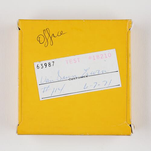 Small square yellow box with handwritten label.