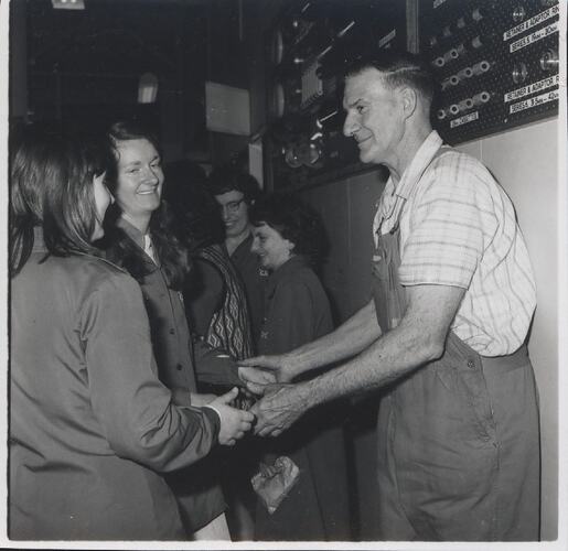Elderly man holds two women's hands.