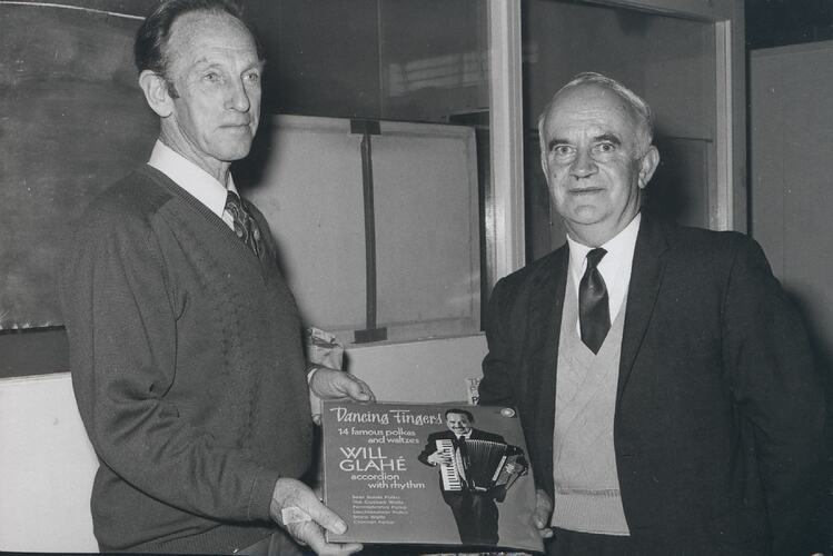 Two men holding vinyl Will Glahe record.