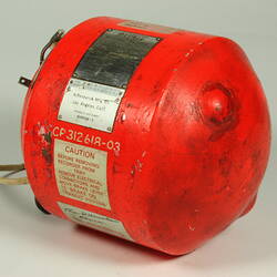 Red cylindrical container with two electrical cords at one end.