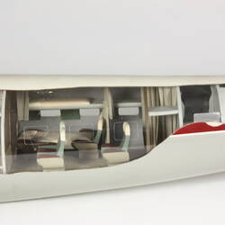 Model plane, tail section. Cut-out side exposes white, green interior and passenger seats.