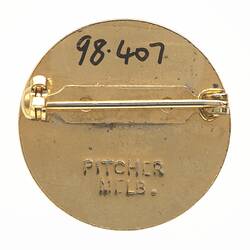 Back of round metal pin badge.