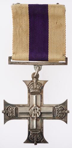 Silver cross medal suspended from silver bar on white ribbon with central purple stripe.