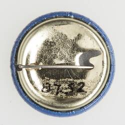 Metal back of round badge. Horizontal pin.