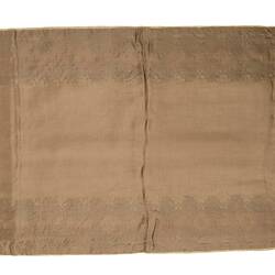 Back of rectangular brown silk lined table runner. Gold fringing on ends.