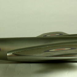 Silver model aeroplane. Profile facing right.