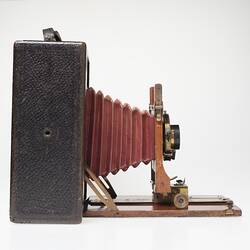 Brown leather-covered camera. Fold out centre, red leather bellows. Right profile.