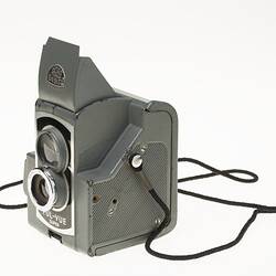 Grey metal camera with two central circles, viewfinder lens and lens. Grey hood on top.