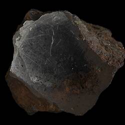 Orange-brown rock with shiny grey surface.