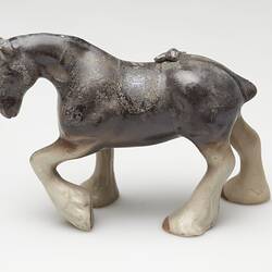 Fire affected brown and cream ceramic horse figurine.