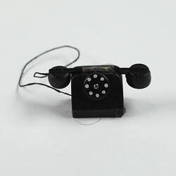 Toy telephone front view, handset on top.